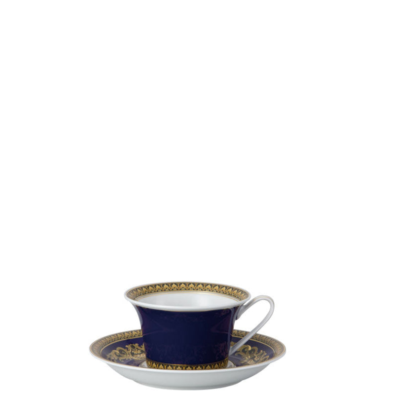 Navy blue teacup and saucer with gold detailing on a white background