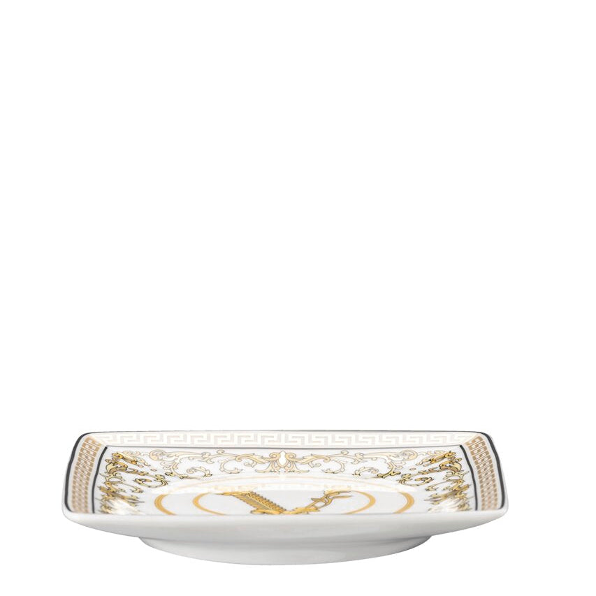 White ceramic dish with gold decorative elements on a white background