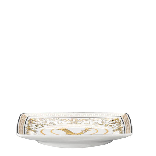 White ceramic dish with gold decorative elements on a white background