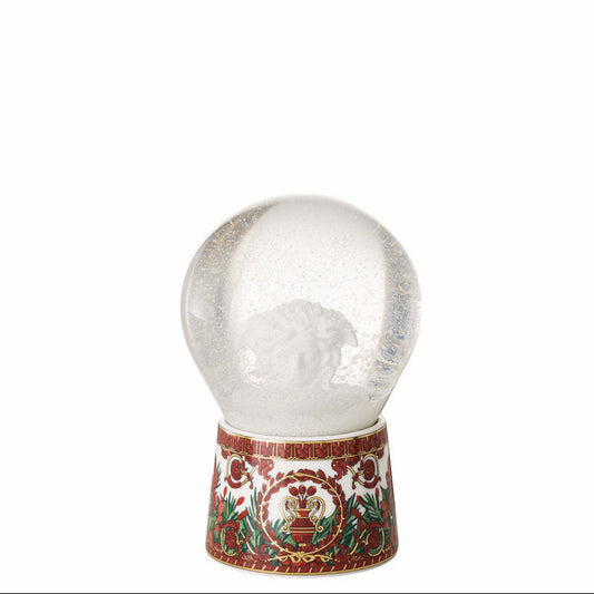 Decorative snow globe with a red and gold base on a white background