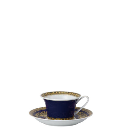Navy blue teacup and saucer with gold detailing on a white background