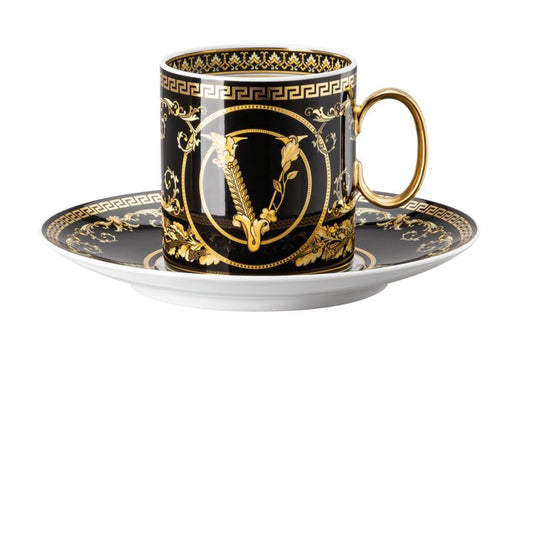 Decorative black and gold cup with saucer on a white background