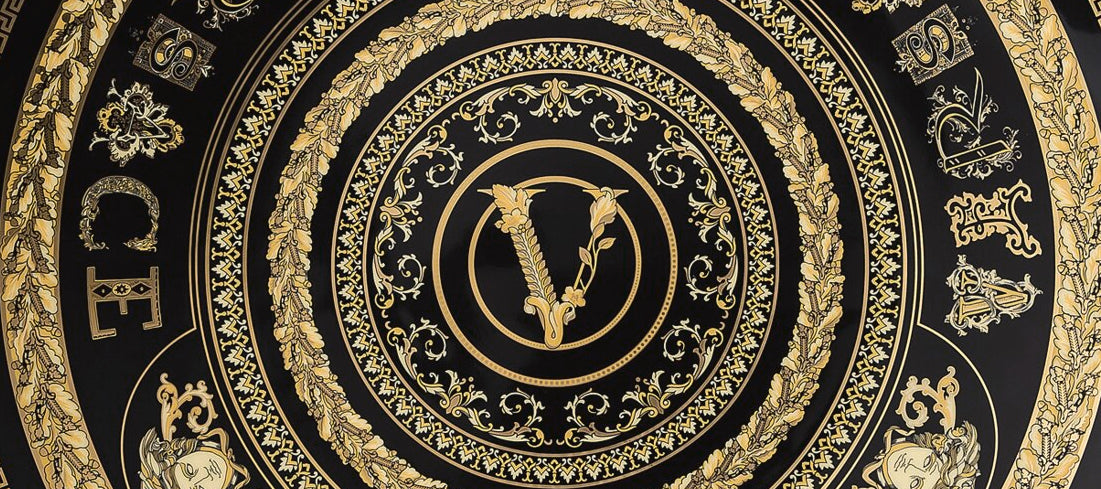 Decorative plate with gold intricate design and 'Vice' text on a black background